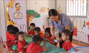 Cô giáo Lê Thị Loan chăm sóc các cháu học sinh trong mỗi bữa ăn hằng ngày. Ảnh: Xuân Tiến - TTXVN