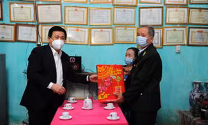 Đồng chí Nguyễn Xuân Thắng, Giám đốc Học viện Chính trị Quốc gia Hồ Chí Minh trao quà cho các hộ gia đình chính sách xã Tân Tiến. Ảnh: Nam Sương - TTXVN