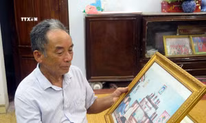 Ông Nguyễn Đình Tính (con trai của cụ Nguyễn Đình Thoa) luôn nâng niu tấm ảnh chụp cùng Tổng Bí thư Nguyễn Phú Trọng tại gia đình vào năm 2005. Ảnh: Thu Hằng - TTXVN
