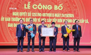 Lãnh đạo tỉnh Bình Định trao Nghị quyết của Thường vụ Quốc hội cho lãnh đạo thành phố Quy Nhơn. Ảnh: Sỹ Thắng - TTXVN