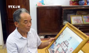 Ông Nguyễn Đình Tính (con trai của cụ Nguyễn Đình Thoa) luôn nâng niu tấm ảnh chụp cùng Tổng Bí thư Nguyễn Phú Trọng tại gia đình vào năm 2005. Ảnh: Thu Hằng - TTXVN