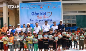 Ban tổ chức trao tặng đồ dùng học tập cho học sinh khó khăn xã Đăk Sơ Mei, huyện Đăk Đoa (Gia Lai). Ảnh: TTXVN phát