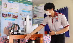 Em Đào Huỳnh Duy An giới thiệu máy hút dịch chanh dây bán tự động. Ảnh: Tuấn Anh – TTXVN