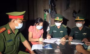 Lực lượng Đồn Biên phòng Hồ Le và Công an xã Ia Dal, huyện Ia H’Drai (Kom Tum) tuyên truyền, vận động người dân ký cam kết thực hiện các biện pháp phòng dịch COVID-19 và xuất, nhập cảnh trái phép. Ảnh: Khoa Chương - TTXVN