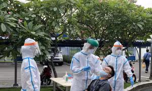 Các y bác sỹ Trung tâm kiểm soát bệnh tật Thành phố Hồ Chí Minh và Quận 7 thực hiện xét nghiệm sàng lọc COVID-19 ngẫu nhiên cho công nhân. Ảnh: Thanh Vũ/TTXVN