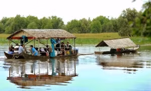 Du khách tham quan Vườn quốc gia Tràm Chim bằng nhà nổi trên sông. Ảnh: An Hiếu/TTXVN