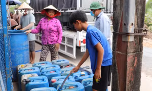 Người dân đến lấy nước tại điểm cấp nước tại ấp Pháo Đài, xã Phú Tân. Ảnh: Minh Trí - TTXVN