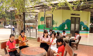 Học sinh đọc sách tại khu vực đọc ngoài trời của Thư viện Cầu vồng, Trưởng Tiểu học Tứ Quận, huyện Yên Sơn. Ảnh: Quang Cường – TTXVN 