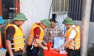 Đoàn công tác thăm hỏi, trao "thùng hàng gia đình" tặng một hộ dân khó khăn tại vùng lũ xã Đức Long, huyện Nho Quan, tỉnh Ninh Bình. Ảnh: Đức Phương - TTXVN 