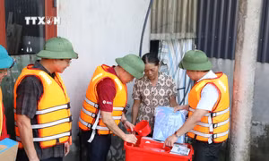 Đoàn công tác thăm hỏi, trao "thùng hàng gia đình" tặng một hộ dân khó khăn tại vùng lũ xã Đức Long, huyện Nho Quan, tỉnh Ninh Bình. Ảnh: Đức Phương - TTXVN 