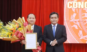 Đồng chí Hồ Văn Niên (phải), Bí thư Tỉnh ủy Gia Lai, trao Quyết định, tặng hoa chúc mừng đồng chí Rah Lan Chung. Ảnh: Quang Thái- Đăng Vũ - TTXVN