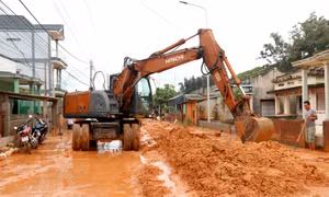 Do lượng cát đỏ quá lớn ngập đường Lạc Long Quân nên việc di chuyển, dọn dẹp cát đỏ rất khó khăn. Ảnh: Nguyễn Thanh - TTXVN
