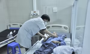 Bác sỹ thăm khám sức khỏe bệnh nhân COVID-19 tại Bệnh viện Thanh Nhàn. Ảnh: TTXVN phát 