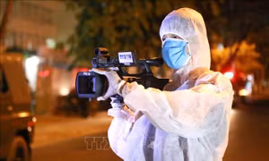 Quay phim Viết Đức (Truyền hình Thông tấn Vnews) tác nghiệp trong khu vực bị phong tỏa. Ảnh: Quốc Dũng – TTXVN
