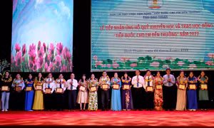 Tặng biểu trưng và hoa cho các đơn vị ủng hộ cho Quỹ học bổng “Tiếp bước cho em đến trường”. Ảnh: Nguyễn Thanh – TTXVN 