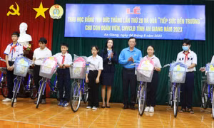 Tặng xe đạp cho các em học sinh là cho con đoàn viên, người lao động vượt khó học giỏi trên đại bàn tỉnh An Giang. Ảnh: Công Mạo - TTXVN 
