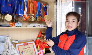 Vận động viên Triệu Thị Phương Thủy bên tủ huy chương các loại mà cô đã giành được. Ảnh: Trung Kiên - TTXVN