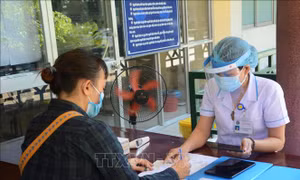 Nhân viên y tế kiểm tra lịch sử dịch tễ của bệnh nhân khi vào khám bệnh. Ảnh: Văn Dũng - TTXVN