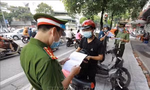 Lực lượng chức năng kiểm tra giấy tờ liên quan của người dân khi tham gia giao thông tại chốt phòng, chống dịch trên tuyến phố Lê Thanh Nghị, phường Bạch Mai, quận Hai Bà Trưng. Ảnh: Vũ Sinh – TTXVN 