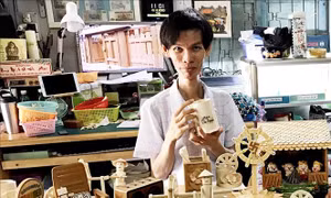  Anh Triệu Hồng Hồ Em cùng các sản phẩm thủ công từ tre. Ảnh: Công Mạo - TTXVN