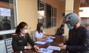Hướng dẫn công dân khai báo y tế điện tử tại các chốt kiểm soát dịch bệnh COVID-19. Ảnh: TTXVN phát