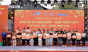 Trao vé xe miễn phí cho đại diện các sinh viên tại chương trình. Ảnh: Hồng Giang - TTXVN.