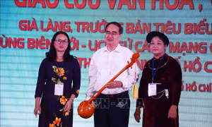 Bí thư Thành ủy Thành phố Hồ Chí Minh Nguyễn Thiện Nhân nhận chiếc đàn tính là quà tặng của Đoàn đại biểu các già làng, trưởng bản dân tộc tiêu biểu các tỉnh biên giới-lịch sử cách mạng phía Bắc. Ảnh: Xuân Khu-TTXVN
