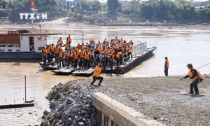 Các lực lượng chức năng vận hành chuyến phà đầu tiên đưa người dân và các phương tiện qua sông Hồng được di chuyển từ phía xã Hương Nộn sang xã Bản Nguyên thay thế cầu phao tạm dừng hoạt động do nước sông Hồng dâng cao. Ảnh: Tạ Toàn - TTXVN 