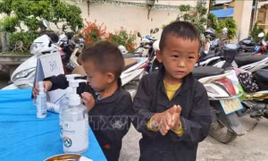 Hai học sinh lớp 1 thực hiện rửa tay sát khuẩn trước khi vào dự lễ khai giảng. Ảnh: Nguyễn Chiến - TTXVN