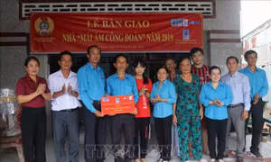 Lãnh đạo Liên đoàn Lao động tỉnh Kiên Giang trao bảng “Mái ấm Công đoàn” cho thầy Huỳnh Văn Yêm, đoàn viên công đoàn cơ sở Trường Tiểu học Đông Hòa 3. Ảnh: Lê Huy Hải - TTXVN