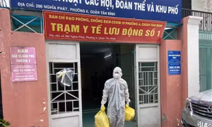 Lực lượng Quân y tại Trạm y tế lưu động số 1 (Phường 6, quận Tân Bình) mang các đồ dùng cần thiết (bình oxy, máy đo nồng độ oxy, ống nghe, nhiệt kế, dung dịch sát khuẩn, khẩu trang…) để đến nhà F0. Ảnh: Mạnh Linh - TTXVN) 