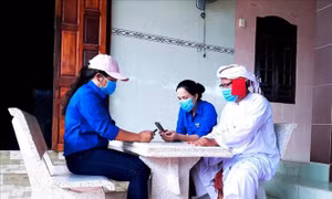 Đoàn viên, thanh niên Ninh Thuận hướng dẫn người dân cài đặt ứng dụng Bluezone trên điện thoại thông minh. Ảnh: Công Thử - TTXVN
