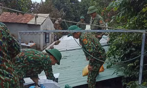 Cán bộ chiến sĩ Đồn Biên phòng Cù Lao Chàm giúp người dân xã đảo Tân Hiệp, thành phố Hội An chèn chống nhà cửa. Ảnh: TTXVN 