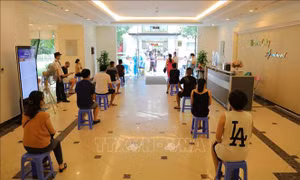Cư dân ngồi giãn cách đợi lấy mẫu xét nghiệm SARS-CoV-2 trong sáng 11/8. Ảnh: Thanh Tùng - TTXVN 