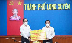 Ủy viên Bộ Chính trị, Phó Chủ tịch Thường trực Quốc hội Trần Thanh Mẫn trao biểu trưng 1 tỷ đồng hỗ trợ công tác phòng, chống dịch COVID-19 cho tỉnh An Giang. Ảnh: Công Mạo-TTXVN 