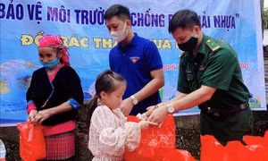 Lực lượng đoàn viên, thanh niên huyện Phong Thổ phối hợp với Đồn Biên phòng Sin Suối Hồ trao quà cho người dân, trẻ em khi đến đổi nhựa. Ảnh: Đinh Thùy-TTXVN 