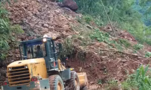Công ty Cổ phần bảo trì đường bộ 1 Lai Châu, đơn vị quản lý tuyến đường huy động máy xúc san gạt đất đá nhằm thông xe trong ngày 8/8. Ảnh: TTXVN phát 