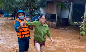 Lực lượng chức năng hỗ trợ người dân bị ảnh hưởng do lũ. Ảnh: TTXVN phát 