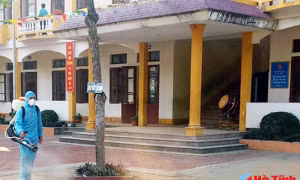 Cán bộ Trung tâm YTDP huyện Nghi Xuân - Hà Tĩnh phun hóa chất Cloramin B khử trùng tại Trường Tiểu học Xuân Mỹ. Ảnh: baohatinh.vn