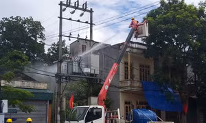 Công nhân ngành điện đang thực hiện nhiệm vụ rửa sứ bảo đảm an toàn cho hệ thống điện trên địa bàn. Ảnh: Đinh Thùy - TTXVN