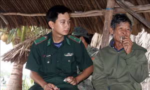 Cán bộ, chiến sỹ Đồn Biên phòng Phú Mỹ đến thăm, động viên ông Lý Văn Nhợi, ngụ ấp Trà Phô, xã Phú Mỹ. Ảnh: Lê Sen – TTXVN