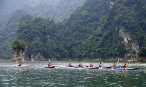 Du khách chèo thuyền kayak khám phá lòng hồ thủy điện Lâm Bình. Ảnh: Nam Sương - TTXVN