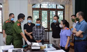 Đối tượng Sùng A Cừ, sinh năm 1999 ở bản Si Ma 2, xã Chung Chải, huyện Mường Nhé, tỉnh Điện Biên chứng kiến ban chuyên án cân heroin tang vật của vụ án. Ảnh: Quý Trung – TTXVN