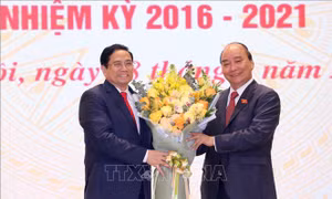 Chủ tịch nước Nguyễn Xuân Phúc, nguyên Thủ tướng Chính phủ tặng hoa chúc mừng Thủ tướng Chính phủ Phạm Minh Chính. Ảnh: TTXVN