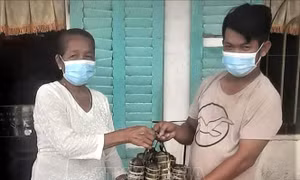 Bà Lý thị Phel (71 tuổi) ở Ấp Phônô Cam Both, xã Tham Đôn, huyện Mỹ Xuyên (Sóc Trăng) gói 50 đòn bánh tét tặng các điểm chốt phòng dịch. Ảnh TTXVN phát