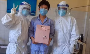 Nhân viên y tế Bệnh viện phổi trong trang phục bảo hộ y tế đến tặng quà cho các em thiếu nhi đang điều trị tại bệnh viện. Ảnh: TTXVN phát