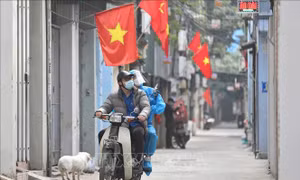 Thành viên Tổ hỗ trợ theo dõi người nhiễm COVID-19 tại nhà ở phường Lĩnh Nam được trang bị đồ bảo hộ, chở oxy bằng xe máy đến tận nhà người bệnh. Việc sử dụng "ATM Oxy" là hoàn toàn miễn phí. Ảnh: Minh Quyết – TTXVN