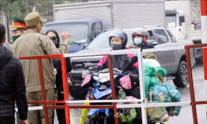 Người dân mang nhu yếu phẩm đến chốt kiểm dịch để cung cấp cho người thân trong vùng phong tỏa. Ảnh: Văn Đức –TTXVN