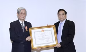 Đồng chí Phạm Minh Chính, Ủy viên Bộ Chính trị, Bí thư Trung ương Đảng, Trưởng Ban tổ chức Trung ương trao tặng Huân chương Độc lập hạng Nhất cho đồng chí Hồ Tiến Nghị. Ảnh: An Đăng - TTXVN