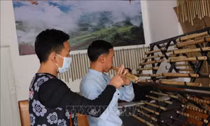 Anh Ma A Cháng, ở bản Sin Câu, xã Giang Ma, huyện Tam Đường hướng dẫn khách hàng thổi sáo. Ảnh: Việt Hoàng - TTXVN 
